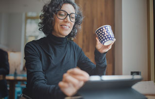 woman in glasses drinking from a mug